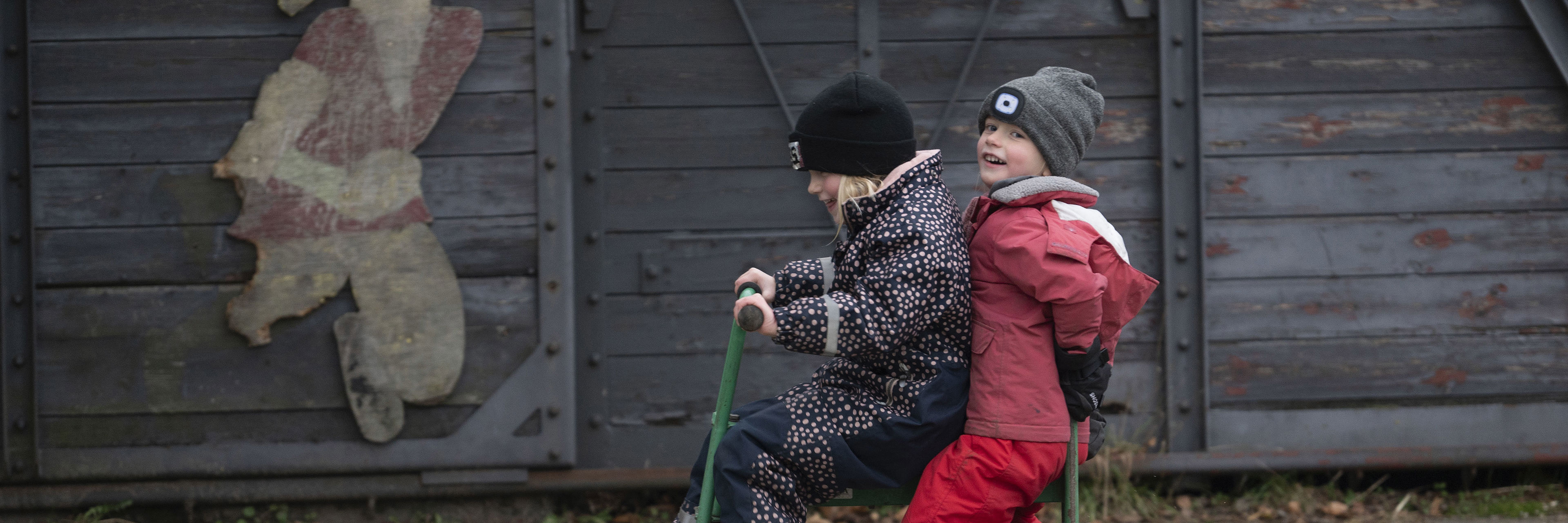 To piger cykler sammen på legepladsen