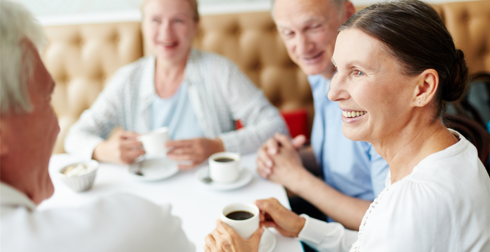Folk taler sammen med kaffekopper i hænderne