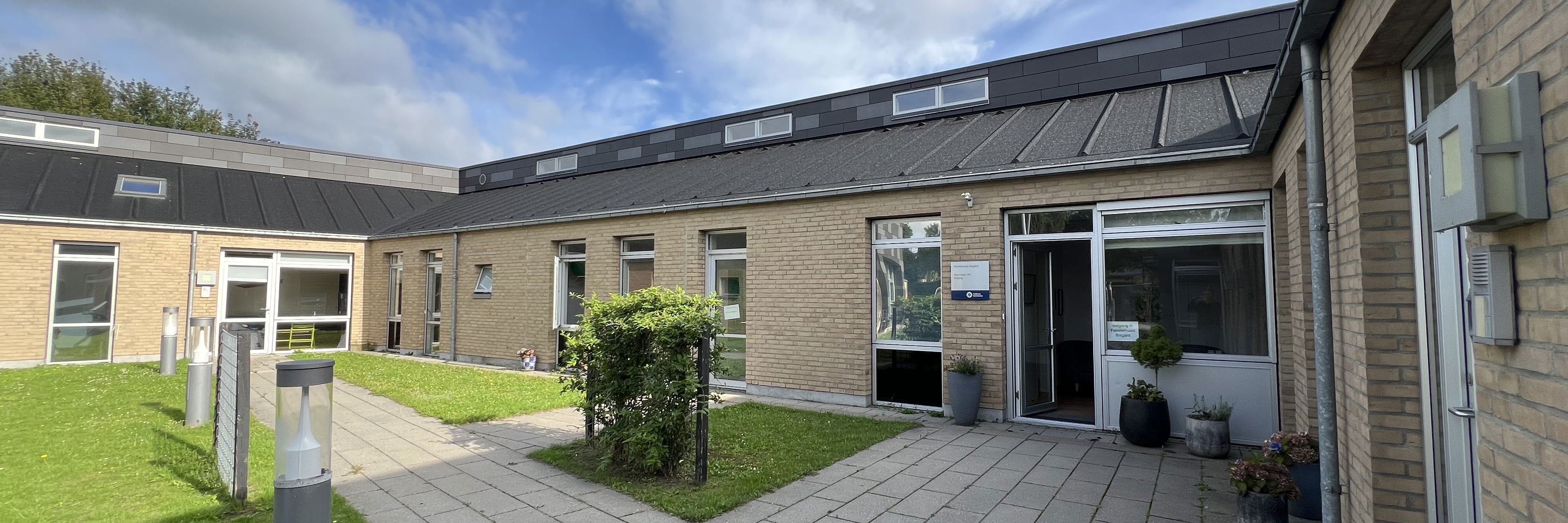 Familiehuset Bisgård Udefra med græsplæne og terrasse
