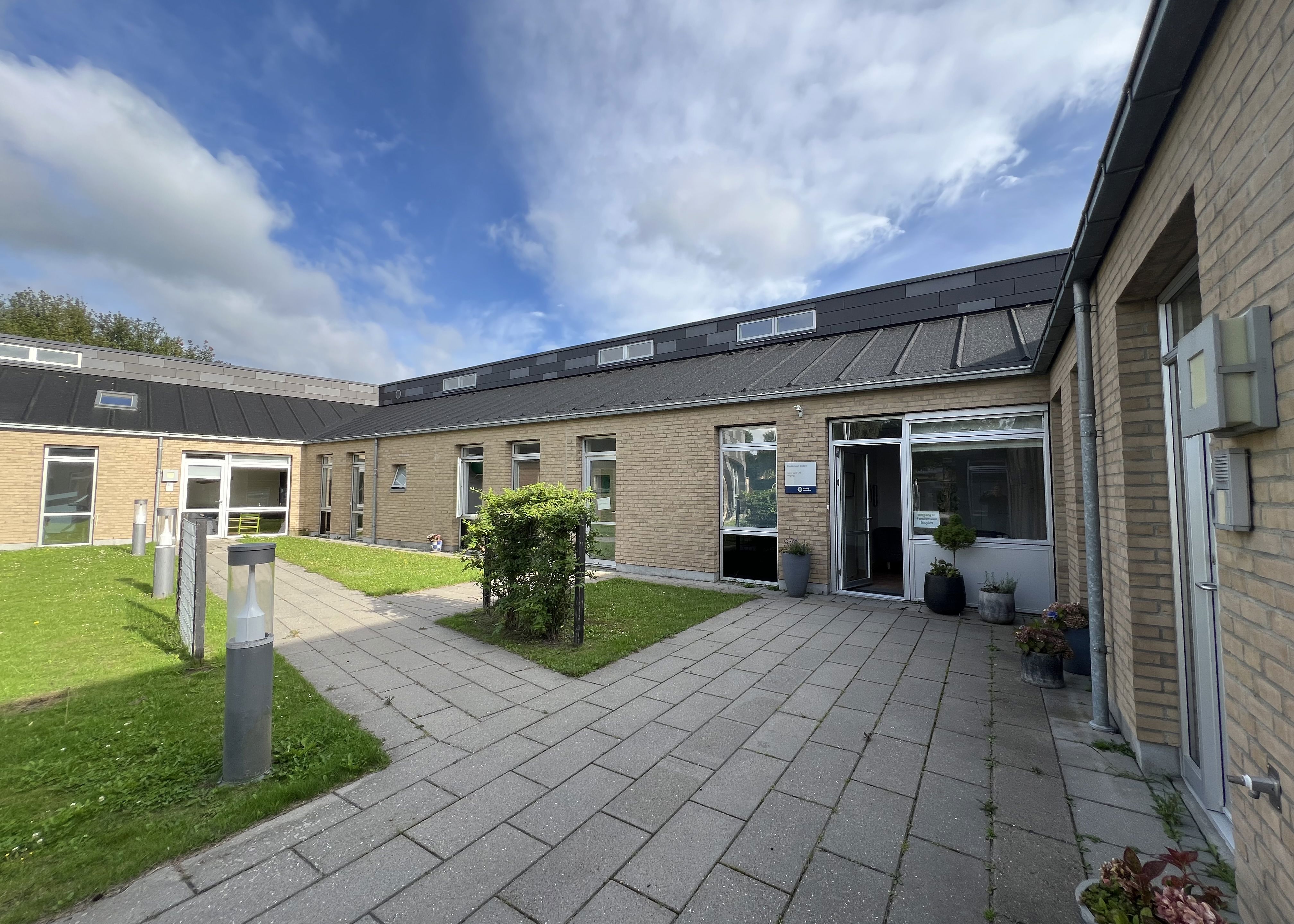 Familiehuset Bisgård Udefra med græsplæne og terrasse