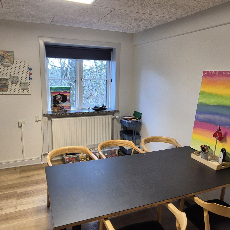Krearum med arbejdsbord, farver og staffeli