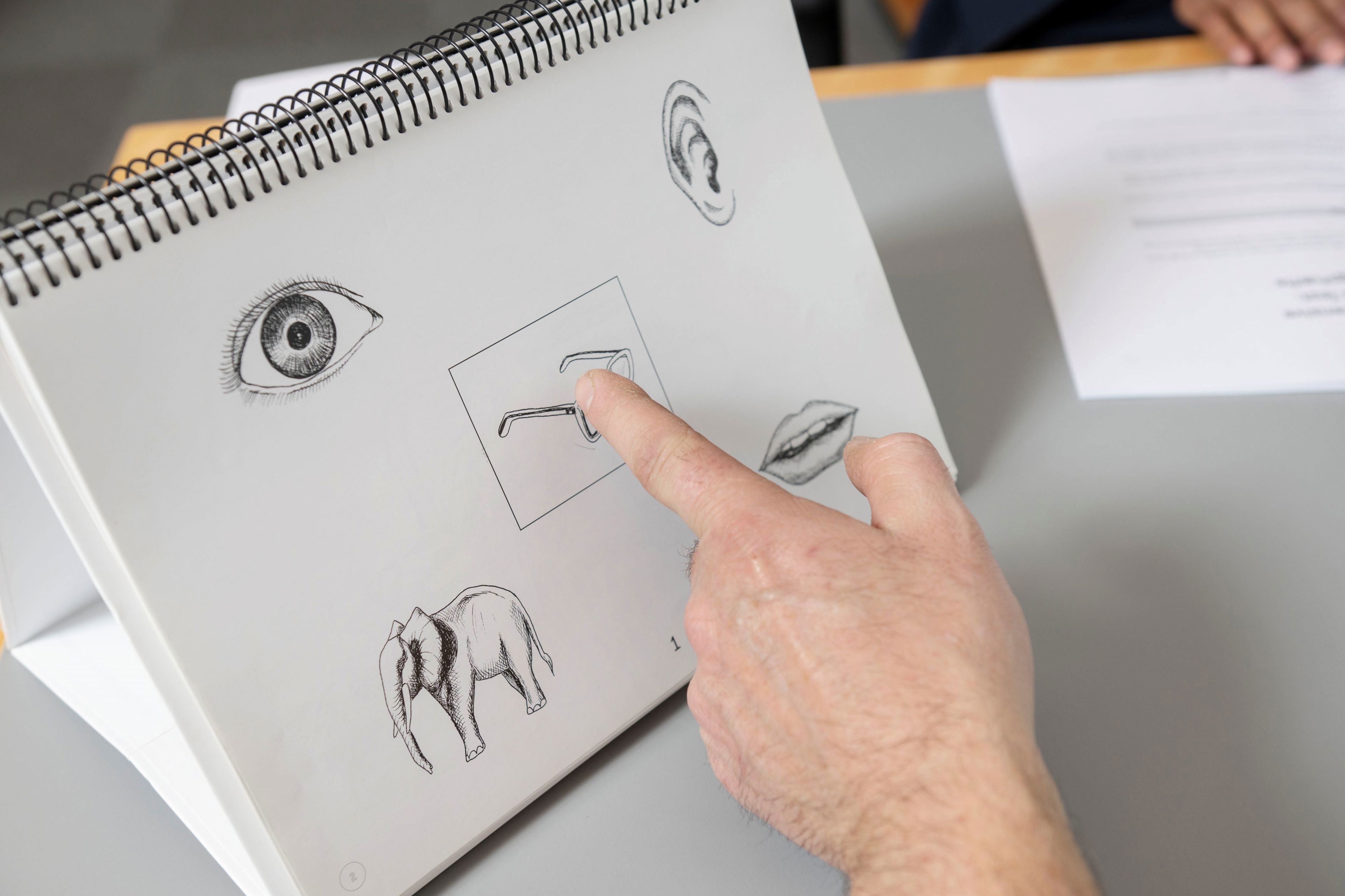 Finger der peger på en tegning med briller