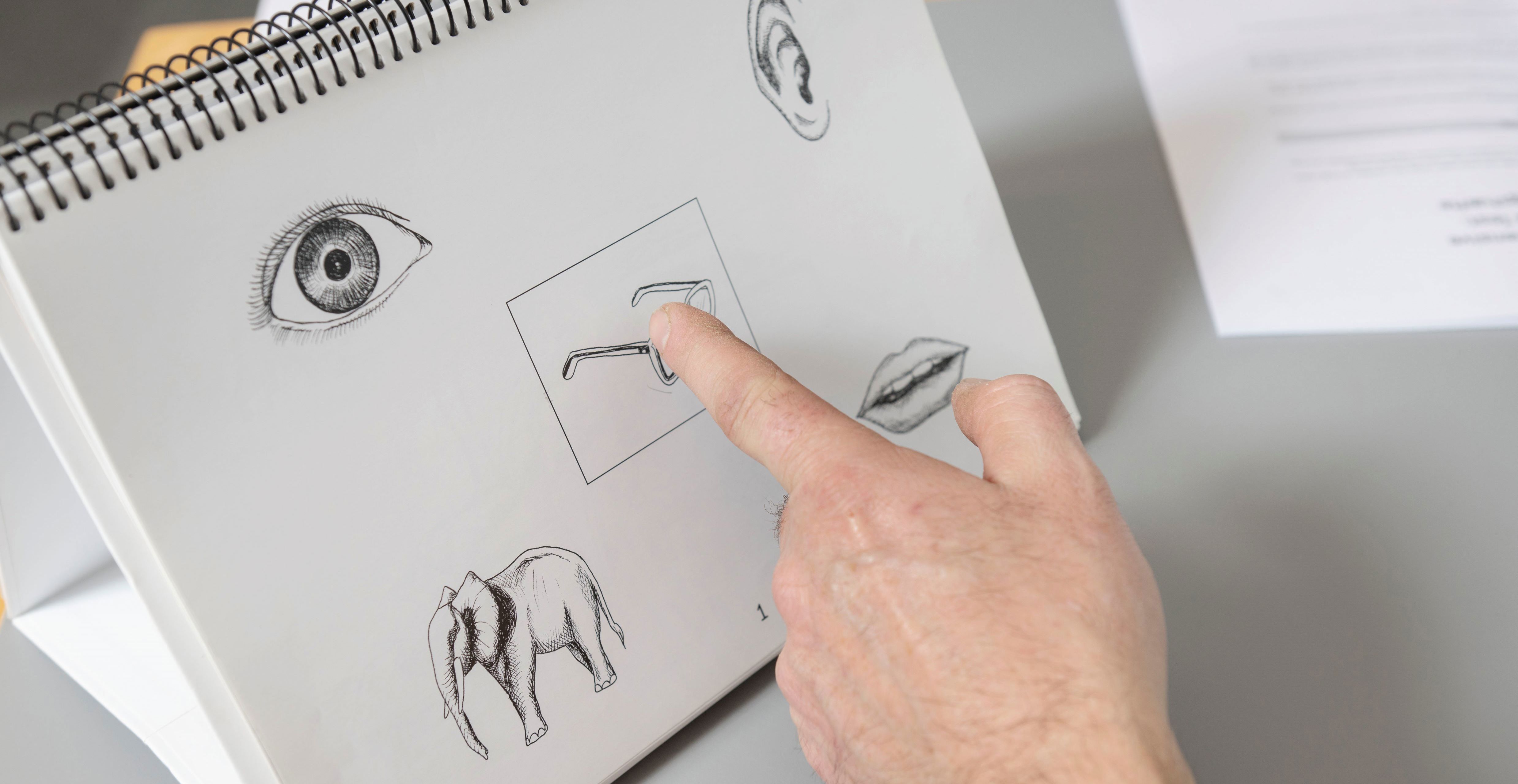 Finger der peger på en tegning med briller