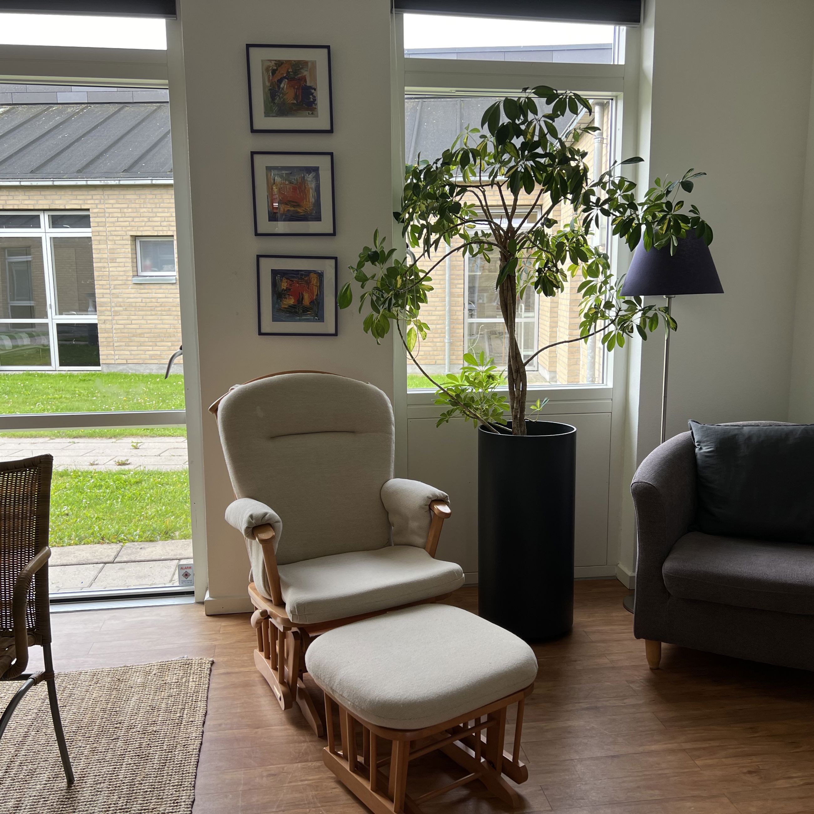 Familiehuset Bisgård Stue med lænestole, grønne planter og billeder