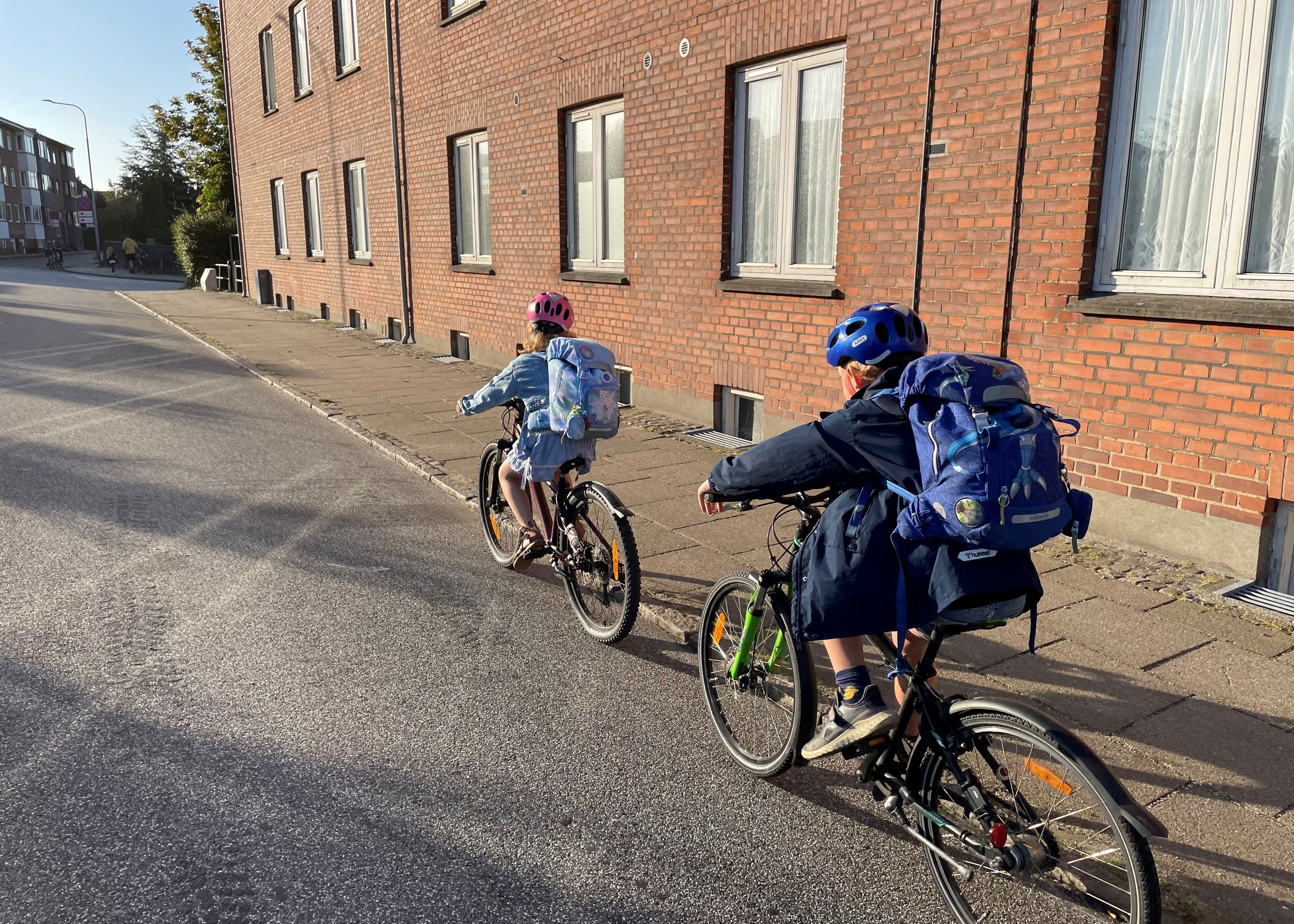 To børn der cykler i et bymiljø.