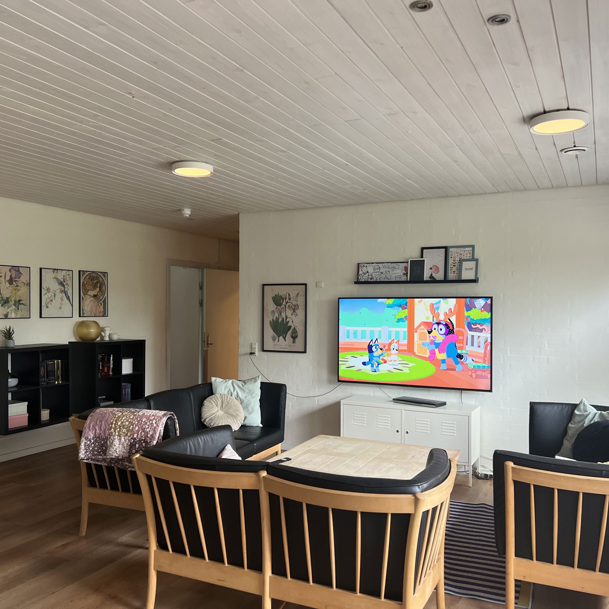 Vokseværket Fællesstue med tv, sofagruppe og reol