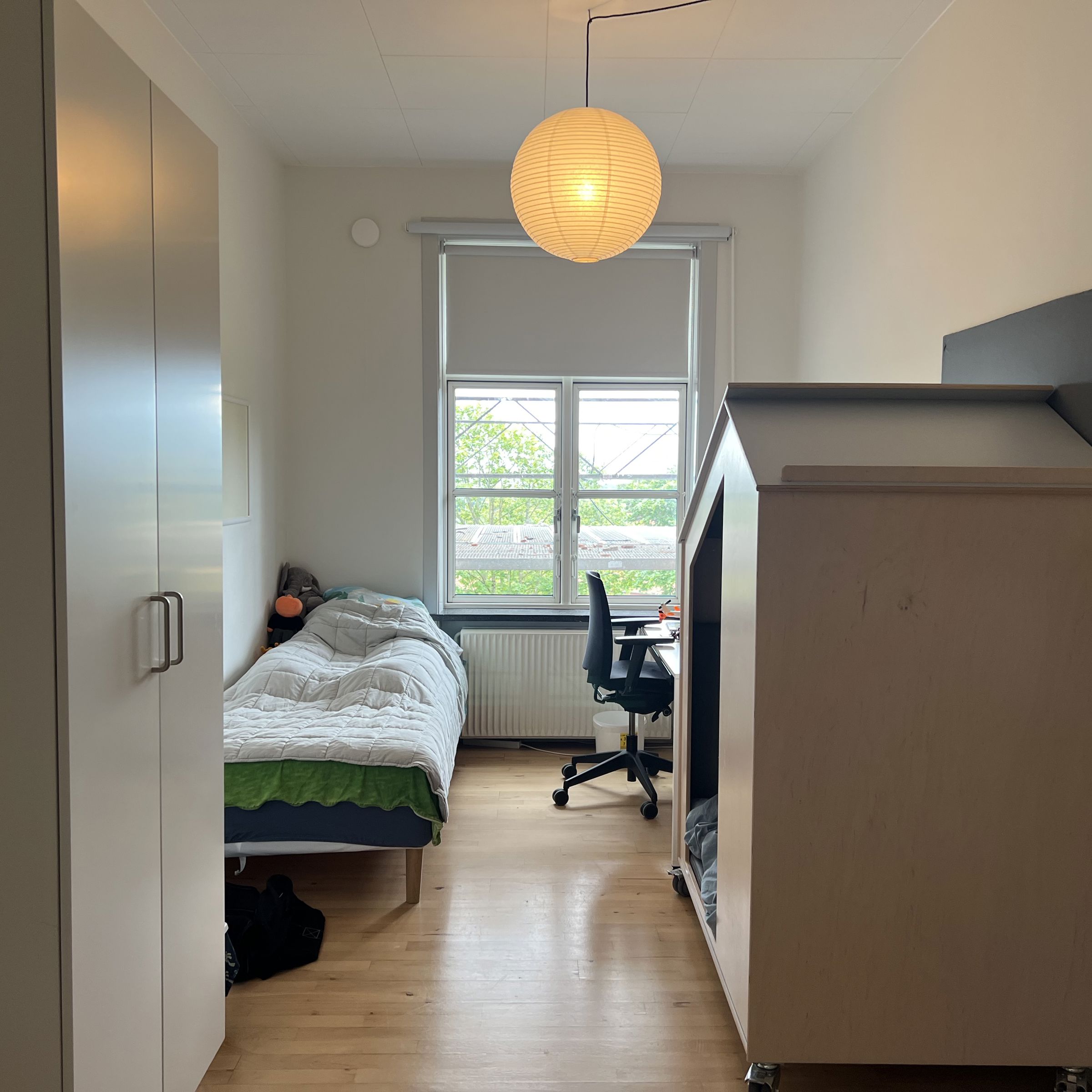 Nøddehuset - et værelse med seng, bord og stol og legehus
