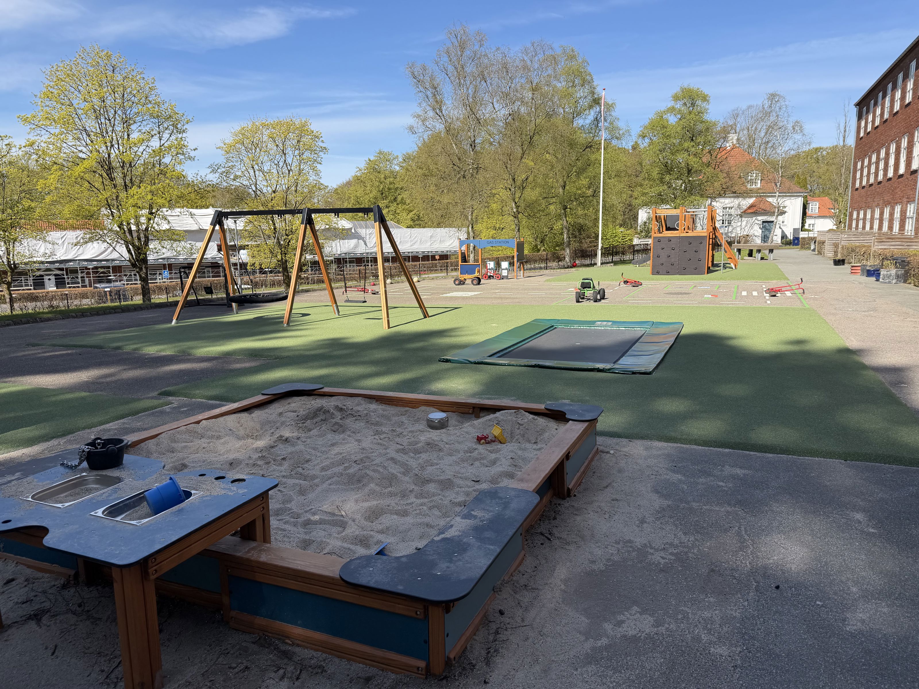 Legeplads med sandkasse, gynger og nedgravet trampolin, Nøddehuset