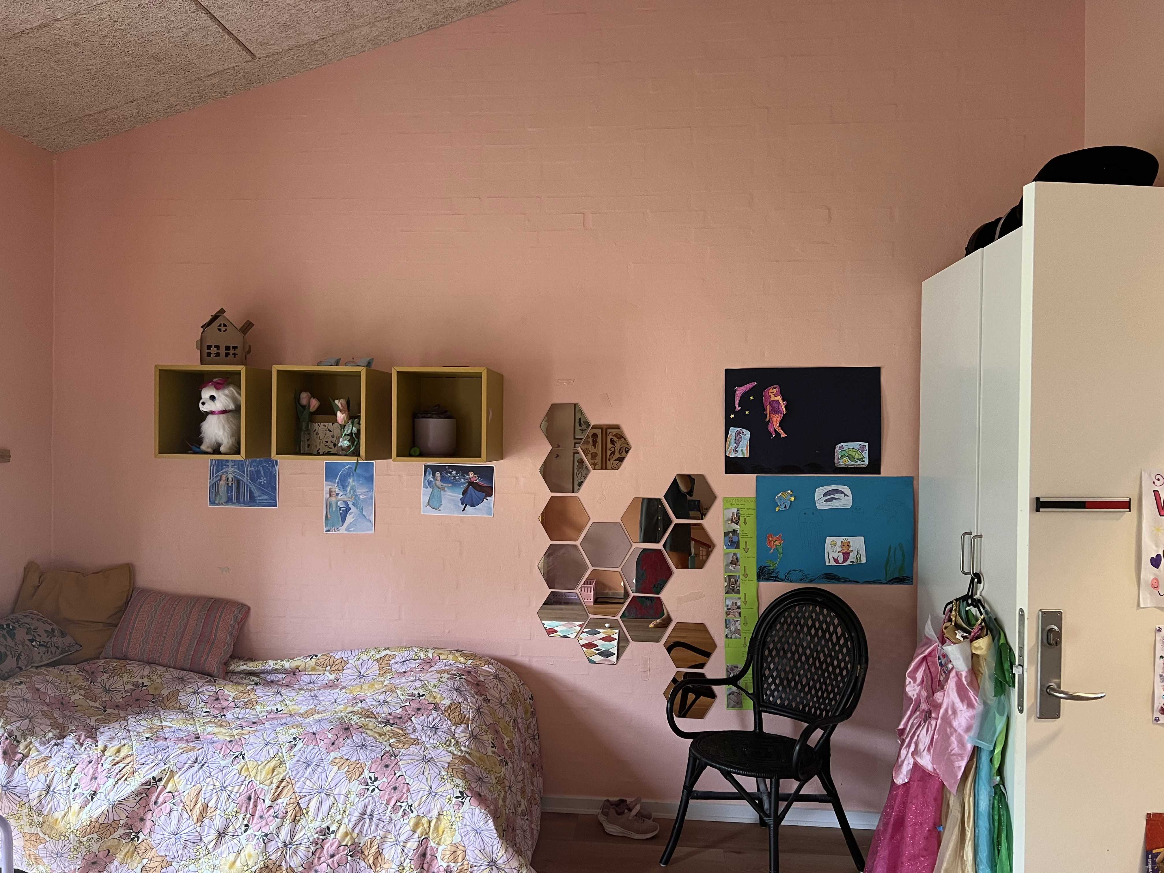 Vokseværket Værelse med seng, stol og bogkasser på væggen